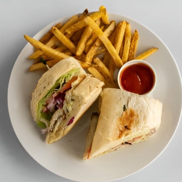 Lighthouse Bistro's chicken wrap, cut in half, served with golden french fries and a side of ketchup.