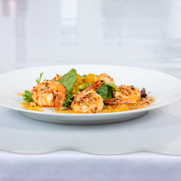 Lighthouse Bistro's shrimp dish with green lettuce, yellow peppers, and a savory sauce.