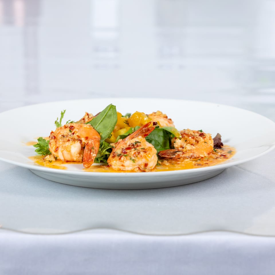Lighthouse Bistro's shrimp dish with green lettuce, yellow peppers, and a savory sauce.