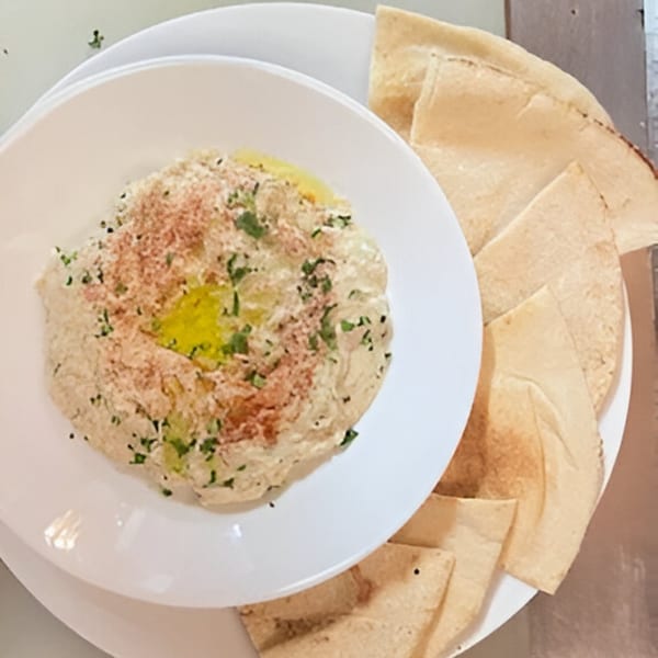 Hummus topped with paprika, parsley, and olive oil, served with pita bread at Lighthouse Bistro.