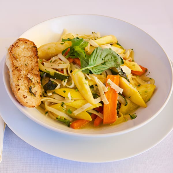 Lighthouse Bistro's vegetable pasta with zucchini, carrots, and basil, served with garlic bread.