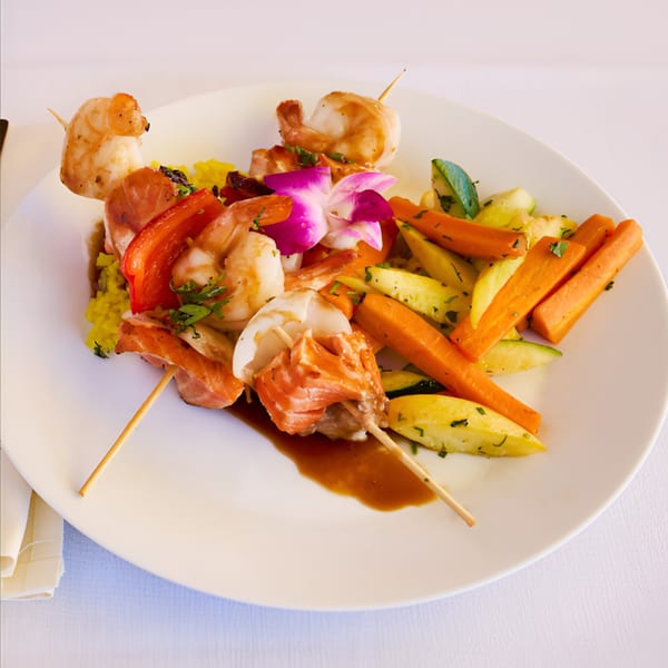 Lighthouse Bistro's seafood skewers with shrimp, salmon, scallops, bell peppers, and roasted vegetables.