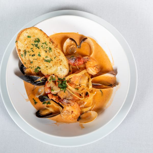 Lighthouse Bistro's seafood pasta with mussels, clams, shrimp, and garlic bread in a creamy sauce.